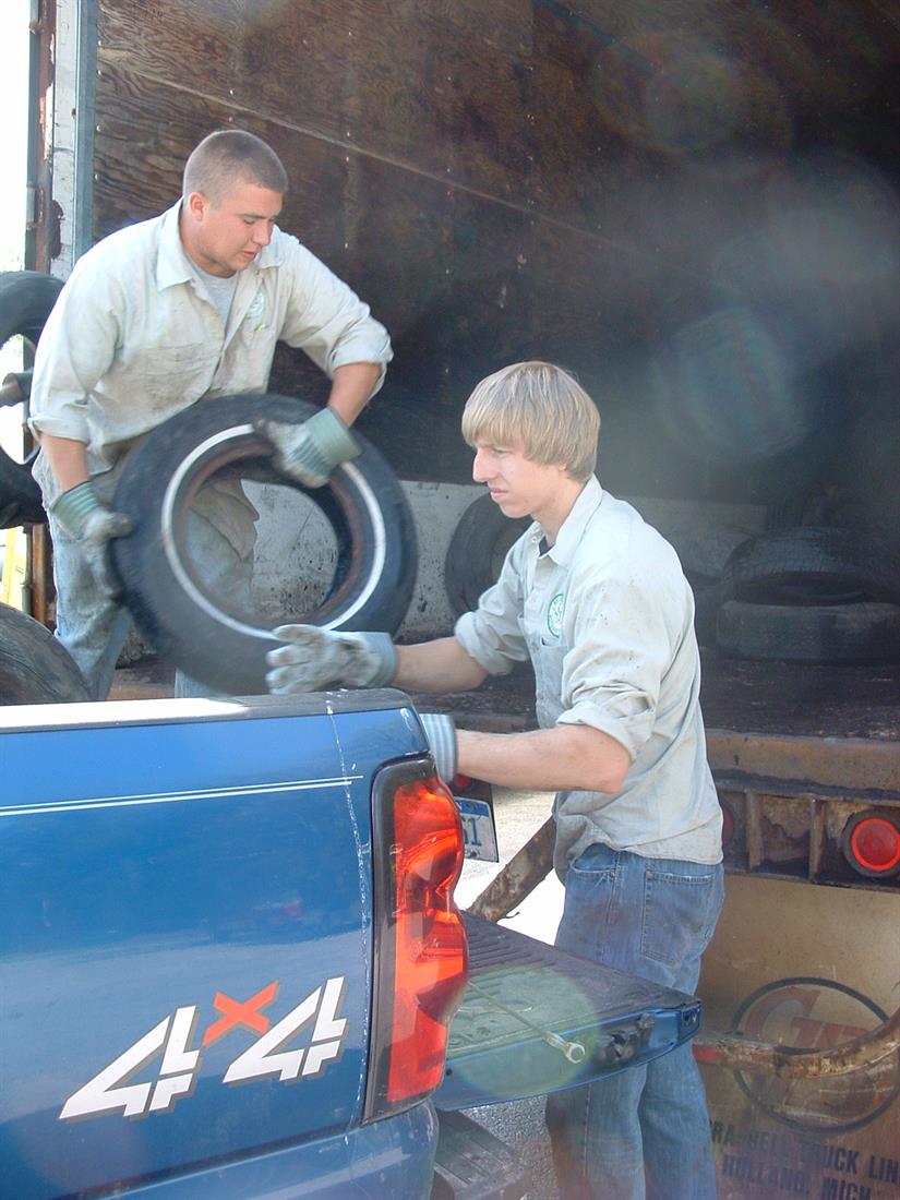 Employees collecting scrap tires.